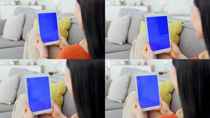 样机，绿屏和平板电脑在她家里的女人手中，屏幕上有跟踪标记。市场营销，用无线技术在沙发上的女性使用的广