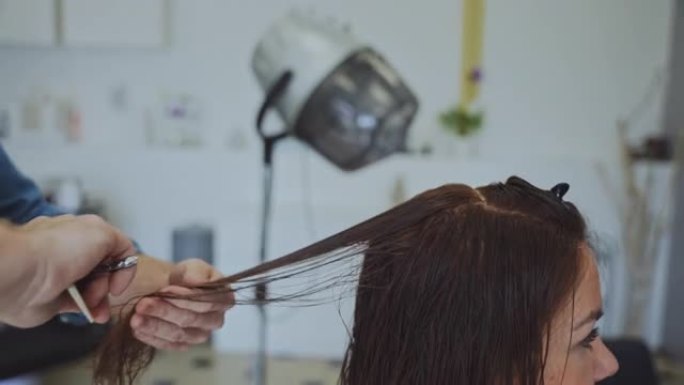 发型师在沙龙梳理女性顾客的头发