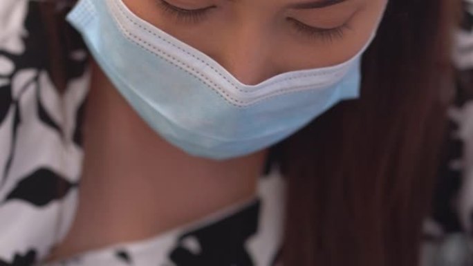 CU-亚洲女性戴着口罩，在智能手机应用投资时担心。