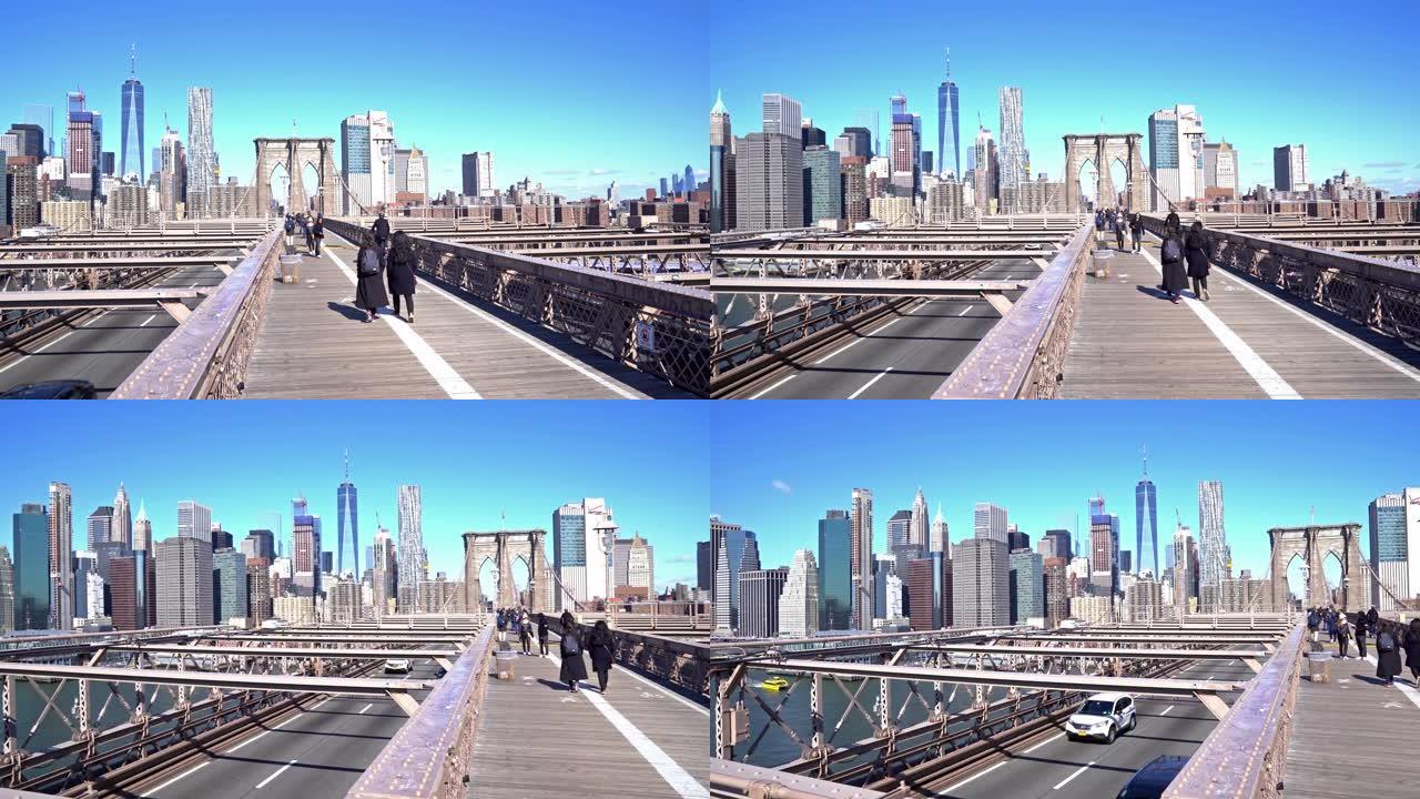 4K UHD Handhel dolly shot: 游客行人在布鲁克林大桥上步行和交通，背景为天际