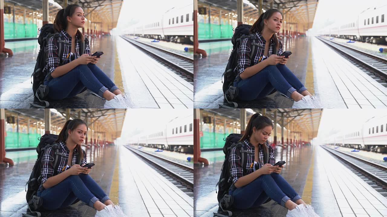 美丽的年轻亚洲女性游客独自旅行，独自坐在火车站。