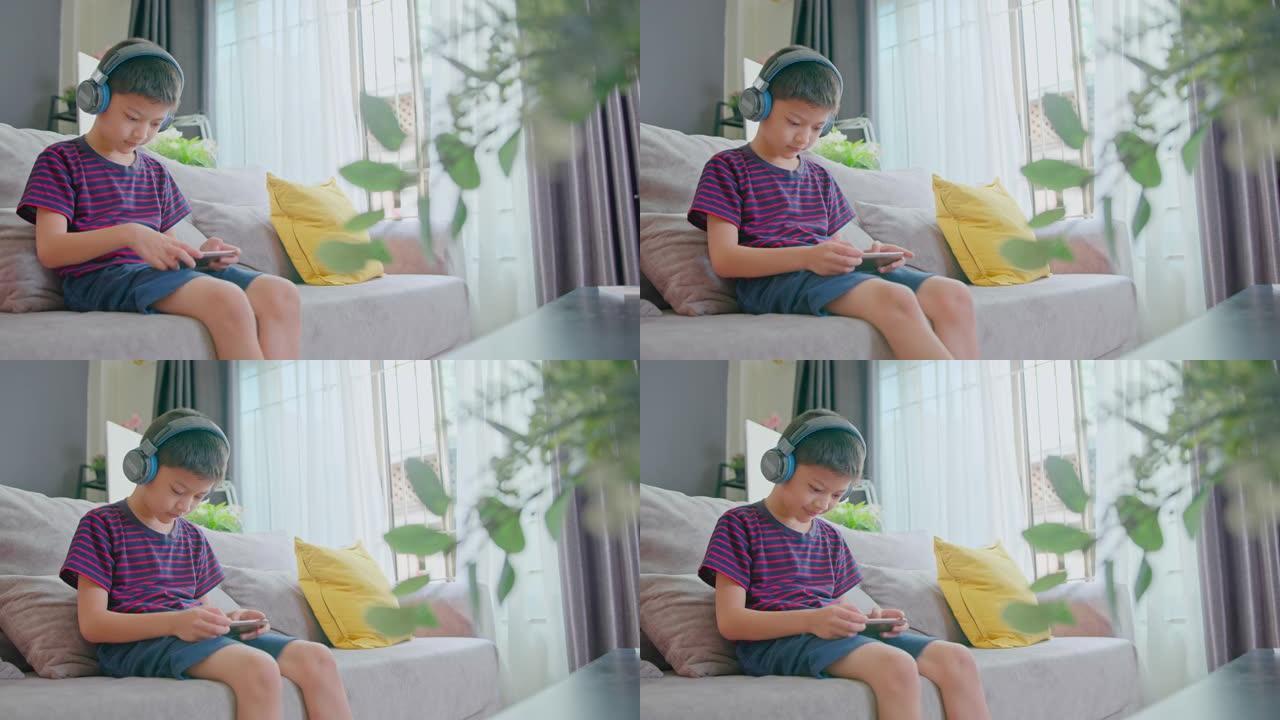 亚洲男学生在家上学的时候用智能手机听在线课。