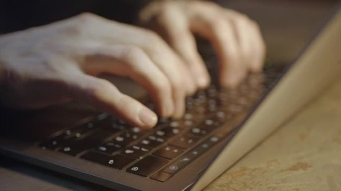 一个在电脑键盘上打字的人的手的特写