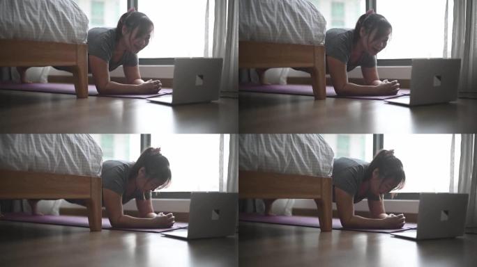 亚洲中国身体积极女性周末在家学习笔记本电脑俯卧撑锻炼