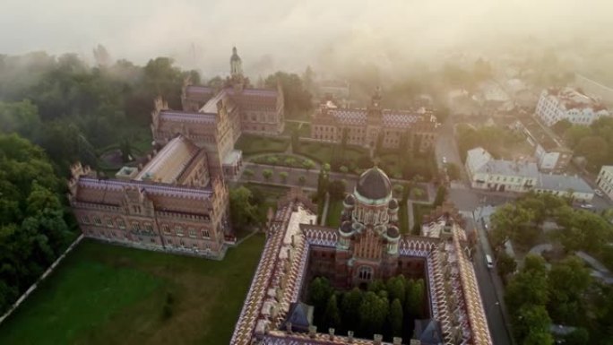 乌克兰切尔诺夫策国立大学驻地的晨雾鸟瞰图。乌克兰切尔诺夫策切尔诺夫策大学的塔楼、圆顶和绿色花园。UH