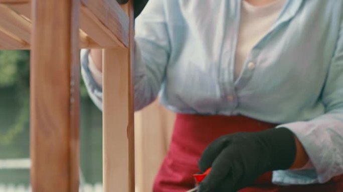 4k视频片段，一名年轻女子在家中从事木制项目