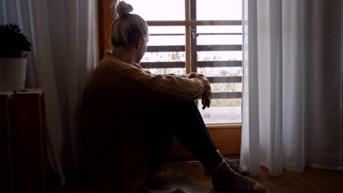 SLO MO沮丧的女人在新型冠状病毒肺炎锁定期间透过窗户看