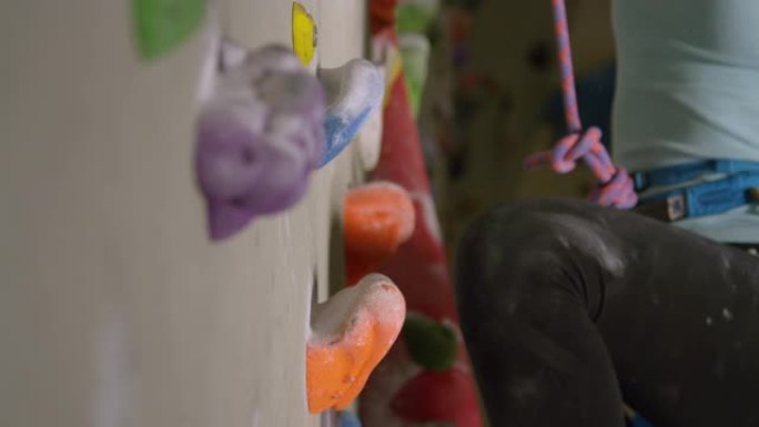 特写镜头，dop: 女孩在室内攀爬时握住橙色的水罐。