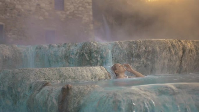 SLO MO女人在Saturnia温泉的热水中沐浴