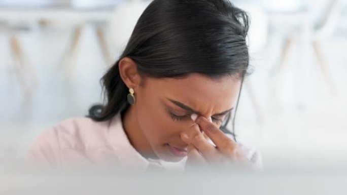 紧张的女商人在办公室的电脑上工作。年轻的忧心忡忡的企业家在与倦怠、眼睛疲劳和因截止日期和压力而头痛的