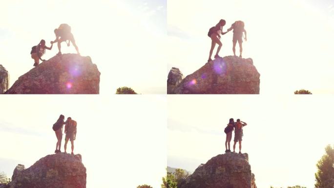 徒步旅行夫妇在日落时分从山顶欣赏风景，并有复制空间。探索自然及其美丽的冒险男人和女人的健身目标。徒步