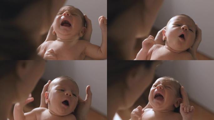 一个新生婴儿在母亲怀里哭泣的慢动作特写。父母安抚她的小宝宝入睡的真实照片。母性、新生活和分娩的概念