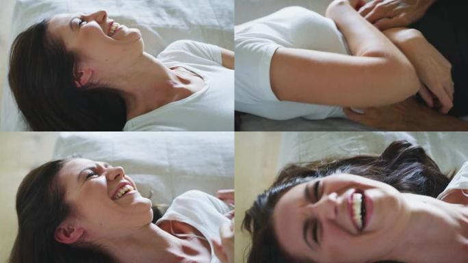 穿着睡衣的年轻新婚夫妇的真实特写镜头很有趣，在早上刚醒来的卧室床上，互相挠痒痒，一起大笑。