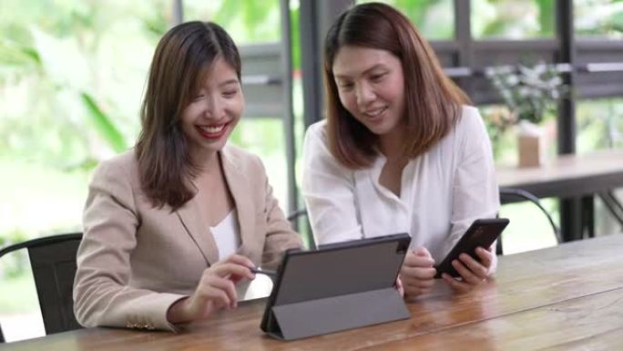 两位女商人一起在数字平板电脑上交谈和讨论