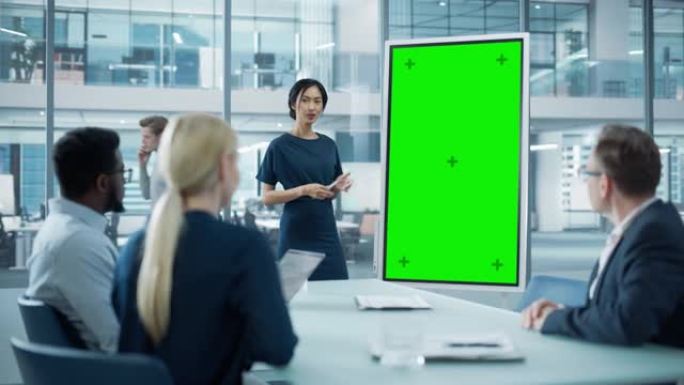 女性运营经理为一组经济学家举行会议演讲。亚洲女性使用带有垂直绿屏模拟显示的数字白板。人们在商务办公室