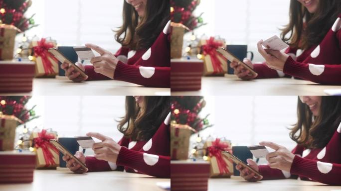 亚洲女性在家圣诞节活动中使用信用卡在线购物