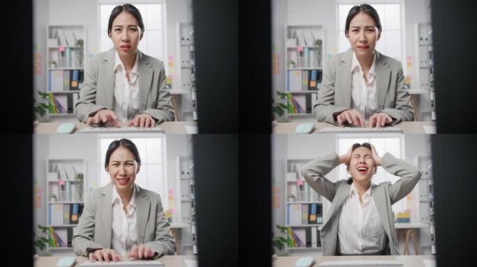 年轻的亚洲女商人坐在桌子上，拿着笔记本电脑，在办公室工作过多的压力下。