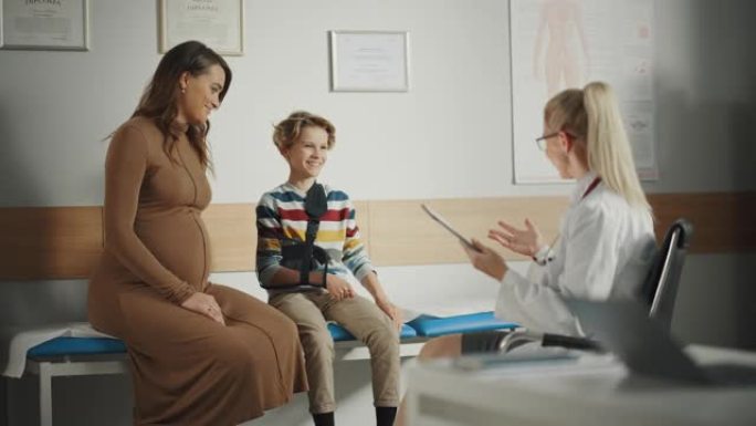女家庭医生与年轻的怀孕妇女和她的十几岁的男孩断臂咨询期间在一个健康诊所。在医院办公室穿着白大褂的有经