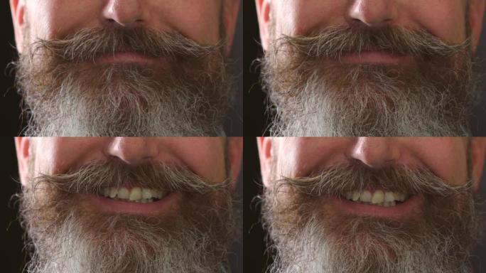 一个微笑的男人的特写镜头，牙齿弯曲，胡须浓密。一个成熟的复古大胡子男性的细节，脸上挂着灿烂的笑容。胡