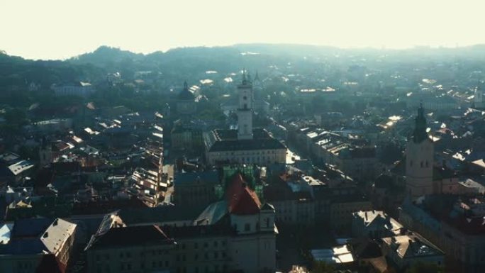 乌克兰利沃夫夏季日出的电影空中全景，古老的市政厅塔楼建筑和历史中心的屋顶。