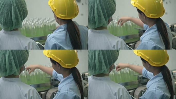 两名工厂工人在传送带上连续检查瓶子