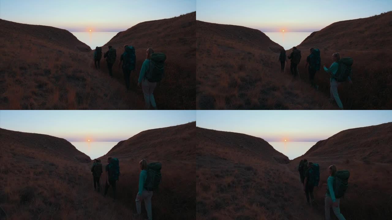 四人在海景背景上爬山。慢动作