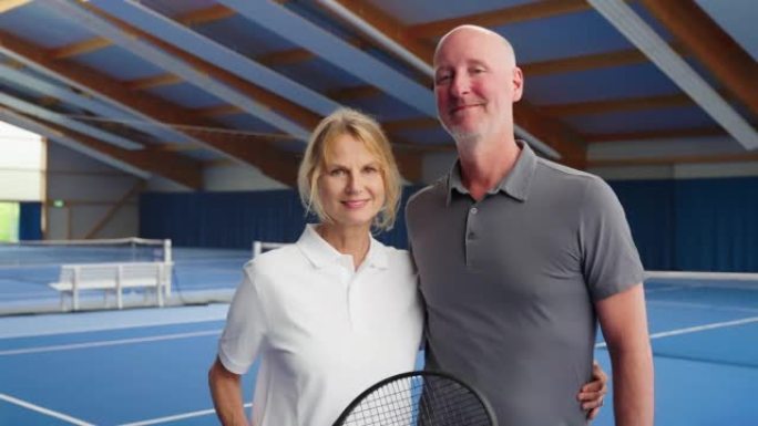 网球场上幸福的成熟夫妇的肖像