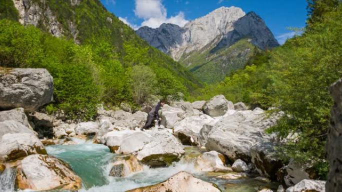 徒步旅行者在山上过河跳过水