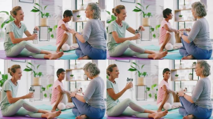 阳光明媚的日子，成熟的女性在现代健康中心上瑜伽课后伸展身体。灵活的臀部老年女士一起在运动垫上聊天，在