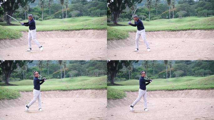 一名亚洲中国高级男子高尔夫球手用铁棍在沙坑中击中高尔夫球