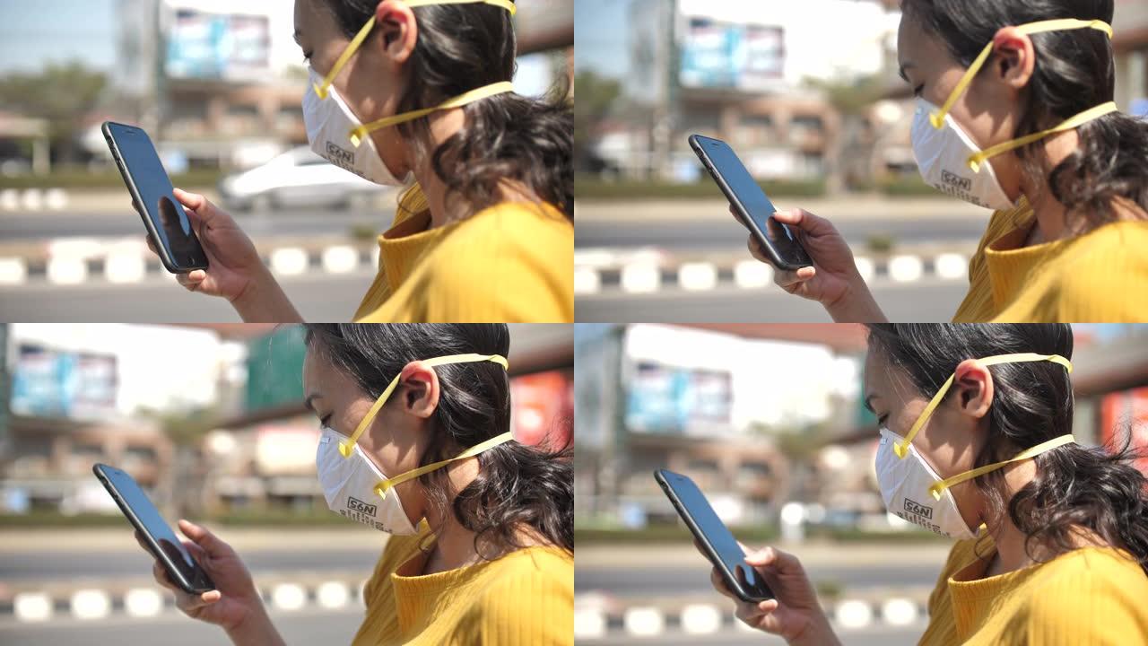 使用带面罩的智能手机的年轻女子