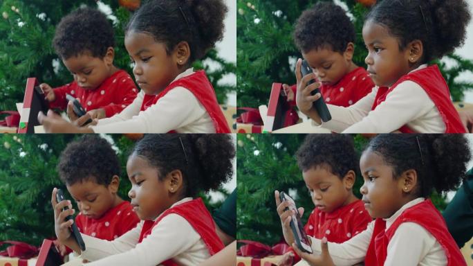 圣诞节那天，两个孩子的快乐家庭非洲民族在视频会议上通过智能手机在家进行视频通话。亲密的圣诞节概念。