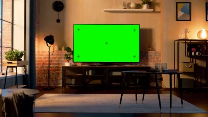 时尚的阁楼公寓内部配有电视，绿屏模拟显示器站在电视柜上。家里空荡荡的客厅，显示器上有色度键占位符。仍