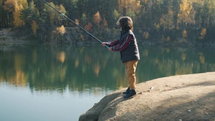 阳光明媚的秋日，儿童在湖中钓鱼的肖像