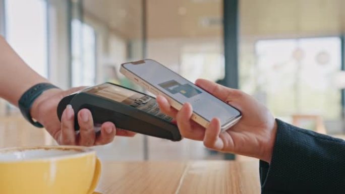 女人在咖啡店用智能手机支付NFC交易的特写镜头
