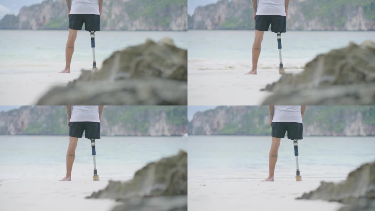 早上在海滩上做伸展运动的假肢残疾人的后视图。残疾收藏: 日常生活概念。