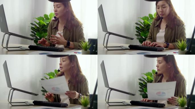 亚洲女性在视频会议中使用笔记本电脑戴耳机