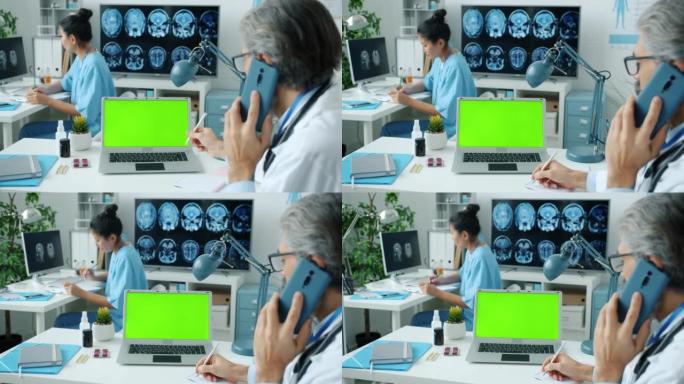 医生在手机上聊天，看着绿屏色键笔记本电脑，护士在后台写作。