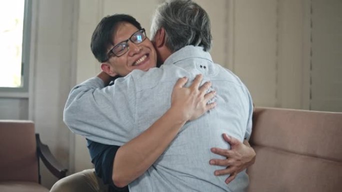 小儿子拥抱他的父亲，在客厅里微笑，慢动作