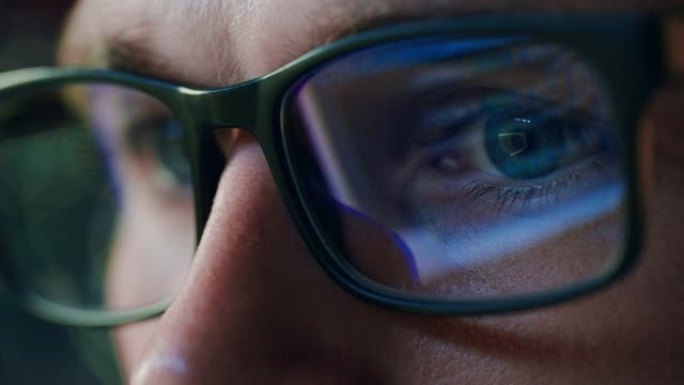 软件工程师在计算机上工作的超级特写肖像，应用程序在眼镜中反射。数字开发人员致力于机器学习、人工智能、