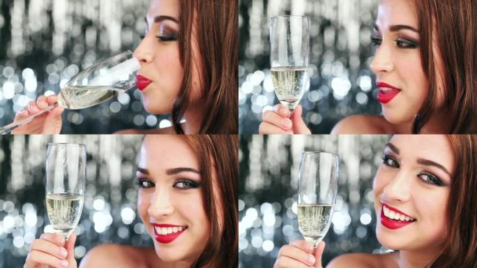 4k视频片段，一名年轻女子在工作室背景下享受一杯香槟