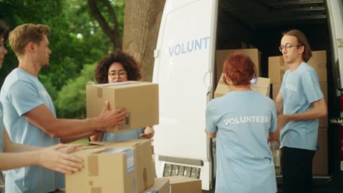 积极的一群勤奋的志愿者准备捐赠的免费口粮，在晴天用货车装载包裹。慈善工作者在当地人道主义援助组织工作