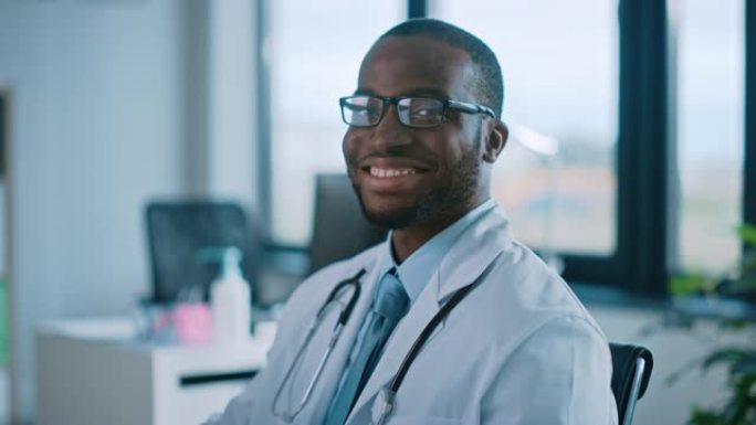 戴眼镜的非裔美国家庭医生正在一家健康诊所工作。穿着白色实验室外套的成功黑人医生看着相机，在医院办公室