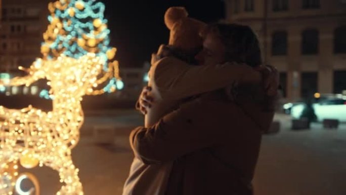 圣诞节期间，年轻夫妇在街上拥抱
