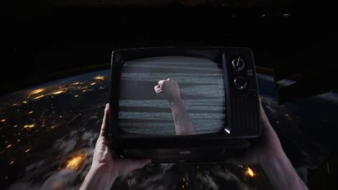 双手握着复古电视在太空中飞越地球。NASA提供的这段视频的元素。