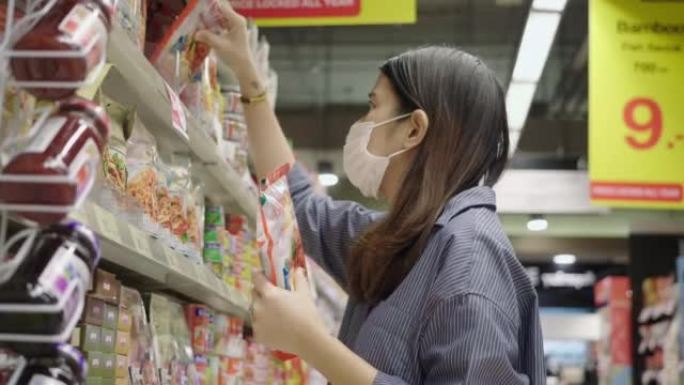 亚洲妇女在杂货店里品尝食物