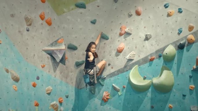 女孩在攀岩健身房攀岩