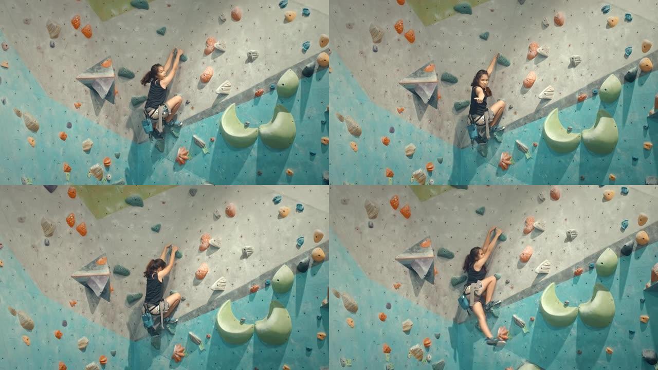女孩在攀岩健身房攀岩