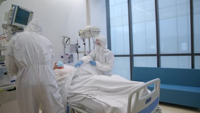穿着PPE的医生团队在新型冠状病毒肺炎大流行期间将患者转移到ICU