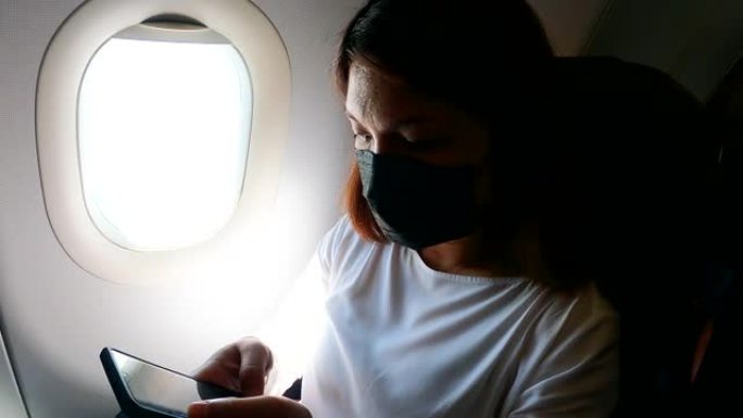 飞机机舱内使用手机的女人